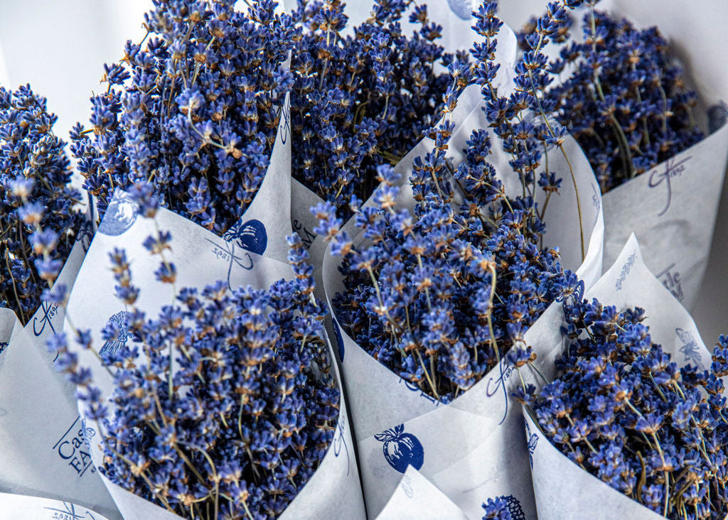Bouquets of dried lavender in white paper packaging with blue butterfly designs.